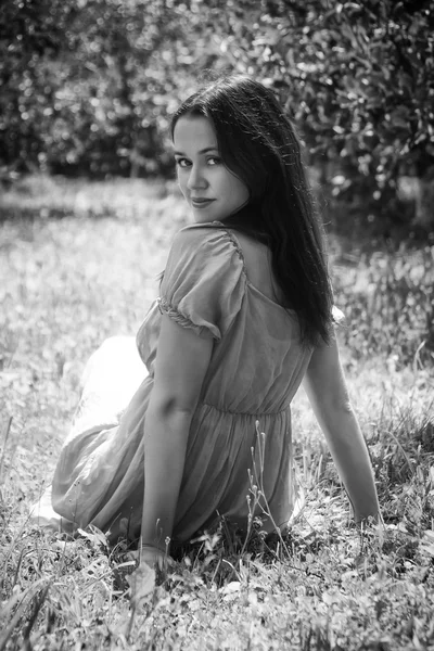 Brunette sitting  in the grass — Stock Photo, Image