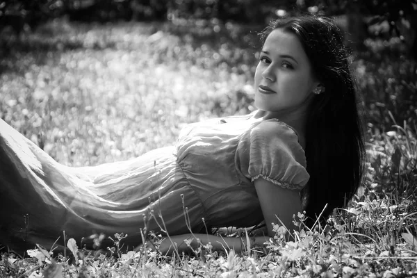 Brunetka ležící v trávě — Stock fotografie