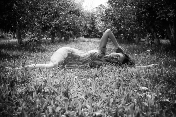 Brunette liggen in het gras — Stockfoto