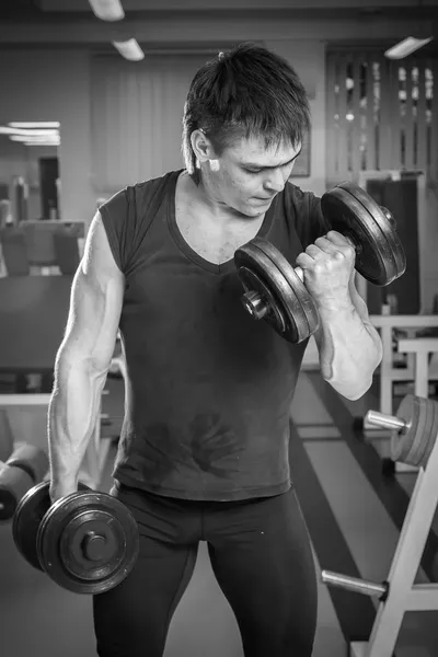 Hombre haciendo ejercicio con pesadas mancuernas — Foto de Stock