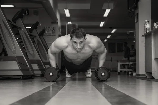 Hombre haciendo ejercicio con pesadas mancuernas — Foto de Stock