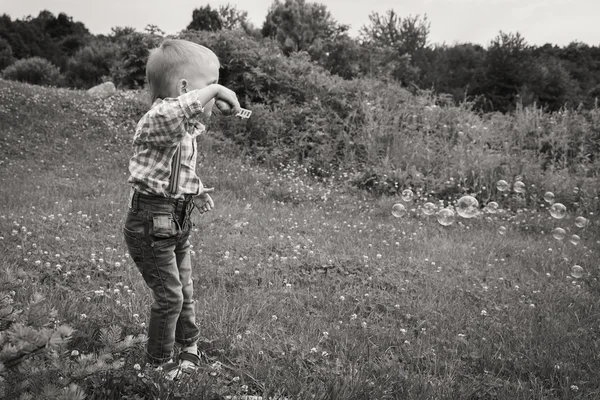 Хлопчик надуває мильні бульбашки — стокове фото