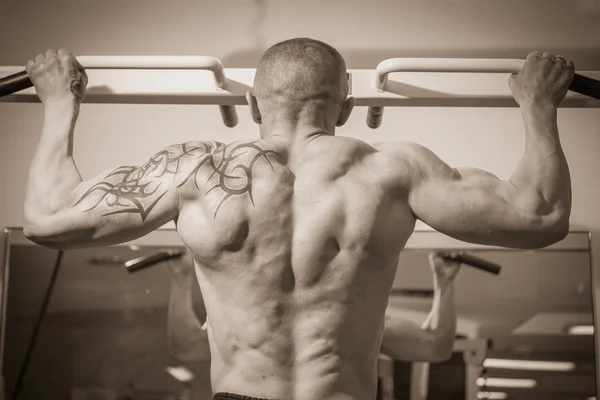 Человек с татуировкой в спортзале — стоковое фото