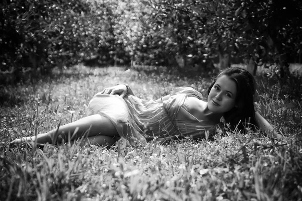 Brunette liggen in het gras — Stockfoto