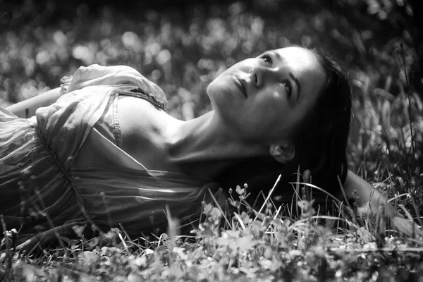 Brunette lying in the grass — Stock Photo, Image