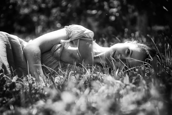 Brunetka ležící v trávě — Stock fotografie