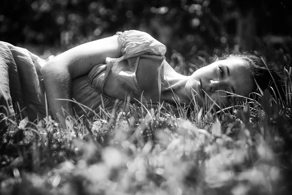Brunette liggen in het gras — Stockfoto