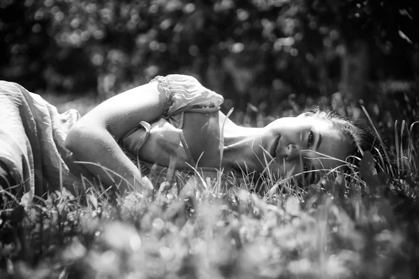 Брюнетка лежачи в траві — стокове фото