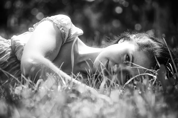 Brunette liggen in het gras — Stockfoto