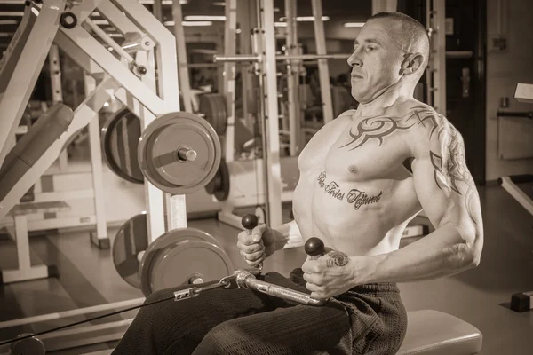 Mannen i tattoo i gymmet — Stockfoto