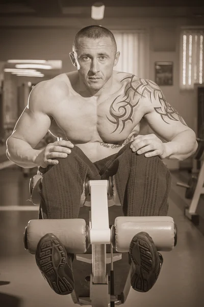 Человек в татуировке в спортзале — стоковое фото