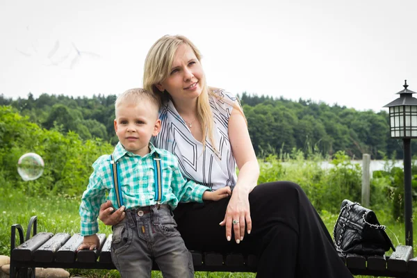 Mamma med son nära källan till vatten — Stockfoto