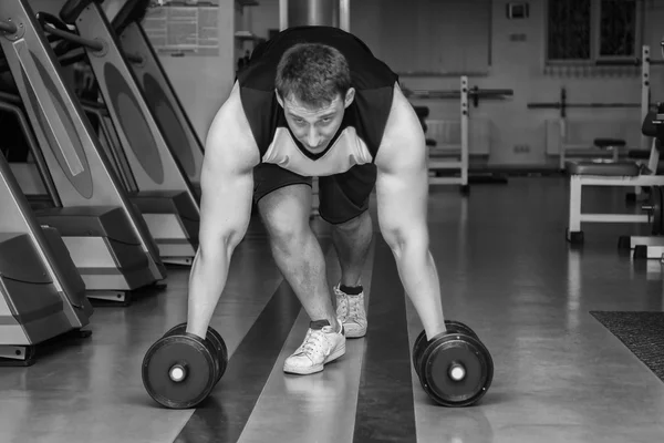 Hombre haciendo ejercicio con pesadas mancuernas — Foto de Stock