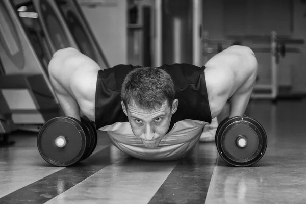 Hombre haciendo ejercicio con pesadas mancuernas — Foto de Stock