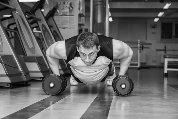 Hombre haciendo ejercicio con pesadas mancuernas — Foto de Stock