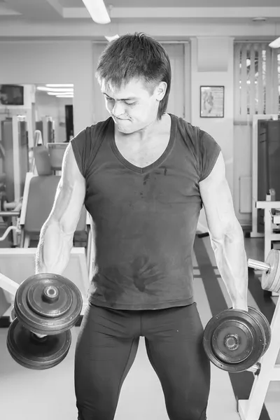 Hombre haciendo ejercicio con pesadas mancuernas — Foto de Stock