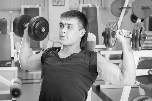 Hombre haciendo ejercicio con pesadas mancuernas — Foto de Stock