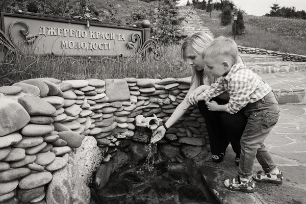 Mother with son near the source of water — Stock Photo, Image