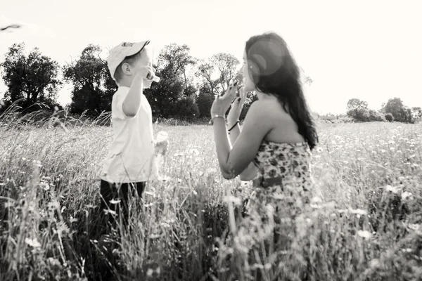 Mutter spielt mit Sohn mit Seifenblasen — Stockfoto