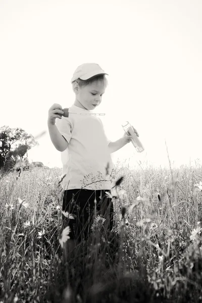 Menino brincando no campo — Fotografia de Stock