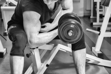adam dumbbells ile çalışmaları yapan.