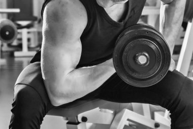 adam dumbbells ile çalışmaları yapan.