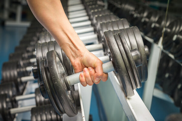 Womans hand holding dumbbell