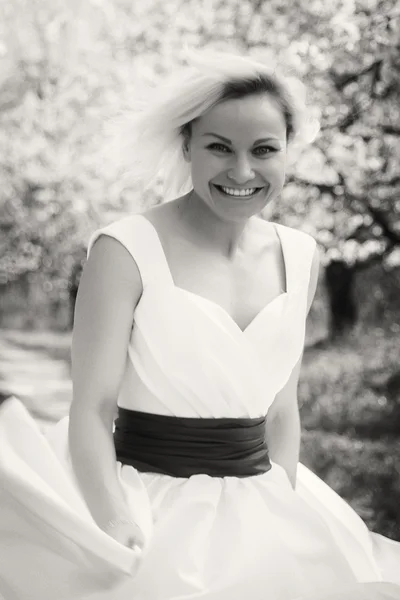 Блондинка в білій сукні в весняному саду — стокове фото