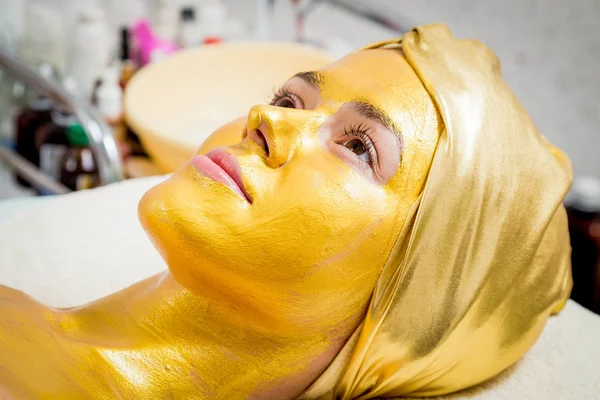 Flickan gör en en gyllene mask — Stockfoto