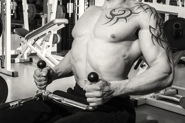 Man in the gym training on simulator — Stock Photo, Image