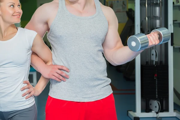 Athletic couple holding dumbbells — Stock Photo, Image