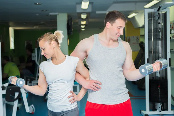 Athletic couple holding dumbbells — Stock Photo, Image