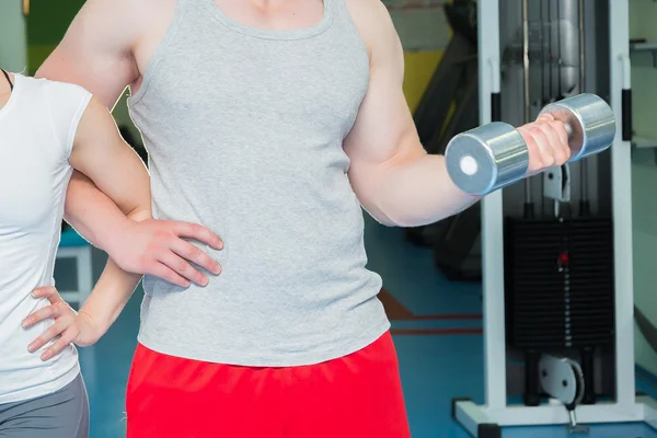 Athletic couple holding dumbbells — Stock Photo, Image