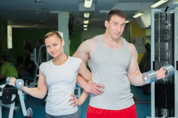 Athletic couple holding dumbbells — Stock Photo, Image