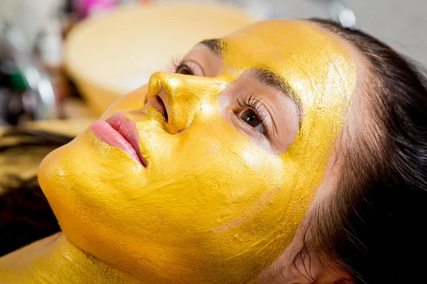 Mädchen macht eine goldene Maske — Stockfoto