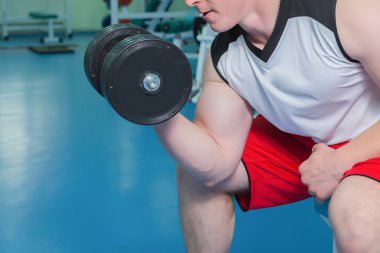 dumbbell ile egzersiz yaparak güçlü bir adam.