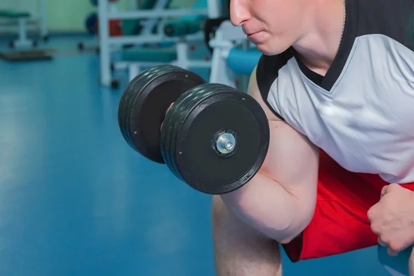 Dumbbell ile egzersiz yaparak güçlü bir adam. — Stok fotoğraf