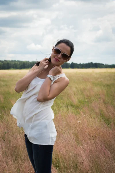 Flicka i solglasögon i fältet. — Stockfoto