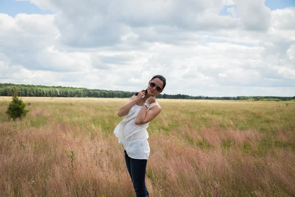 Girl in sunglasses in the field. — Stock Photo, Image