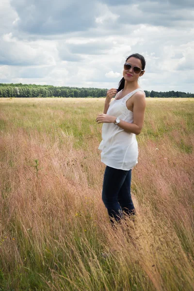 Meisje in zonnebril op het gebied. — Stockfoto