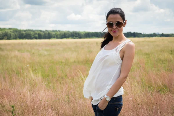 Meisje in zonnebril op het gebied. — Stockfoto