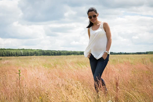 Girl in sunglasses in the field. — Stock Photo, Image