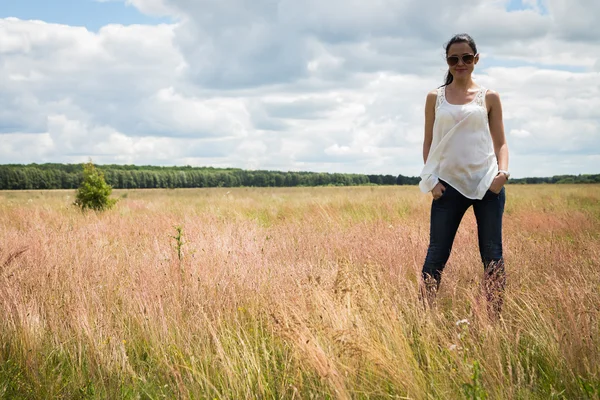 Mädchen mit Sonnenbrille auf dem Feld. — Stockfoto