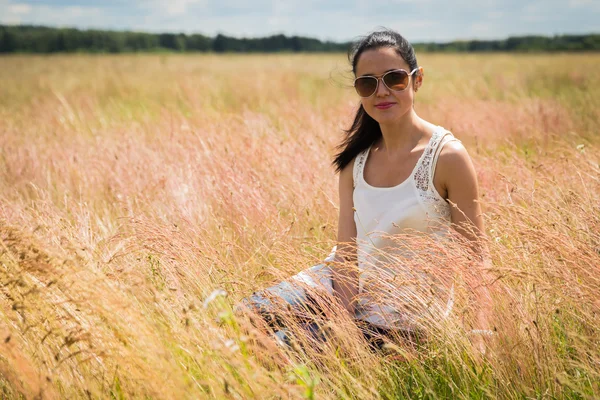 Girl in sunglasses in the field. — Stock Photo, Image