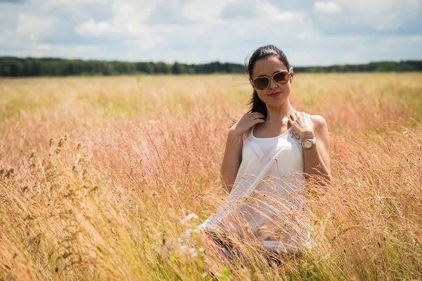 Meisje in zonnebril op het gebied. — Stockfoto