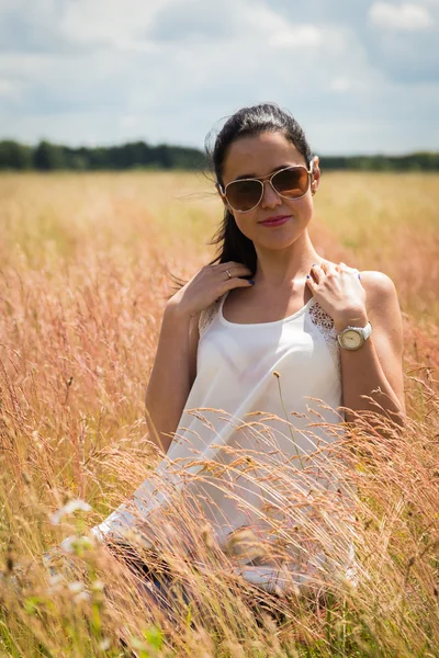 Mädchen mit Sonnenbrille auf dem Feld. — Stockfoto