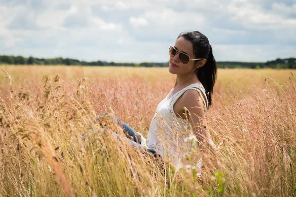 Meisje in zonnebril op het gebied. — Stockfoto