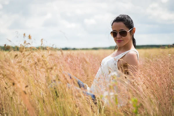 Mädchen mit Sonnenbrille auf dem Feld. — Stockfoto