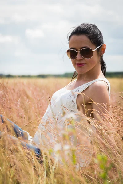 Mädchen mit Sonnenbrille auf dem Feld. — Stockfoto