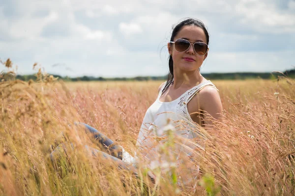 Meisje in zonnebril op het gebied. — Stockfoto